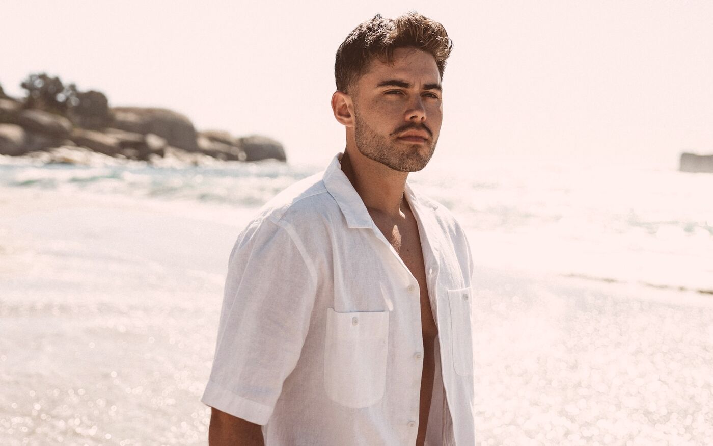 Man in an open silk shirt by the sea